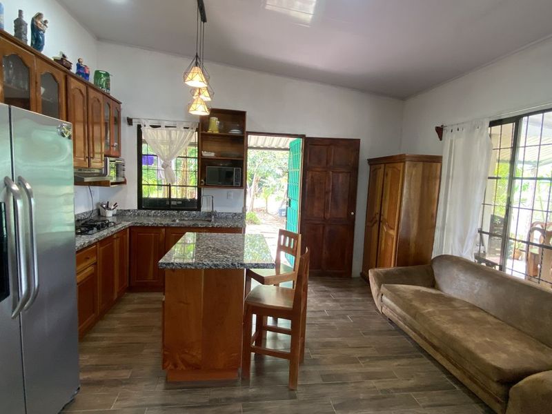 living area with kitchen and sofa in Casa Munoz home for sale samara costa rica